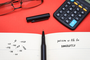 petition to file for BANKRUPTCY with glasses and calculator. calculation of expenses and profits.