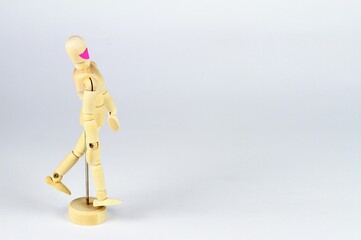 Wooden mannequin with face mask. Figure on the left side, light background