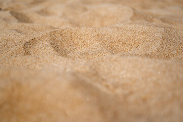 Fototapeta na wymiar Close up of sand shore with blurred sea background.