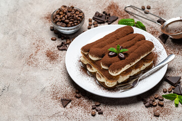 Classic tiramisu dessert on ceramic plate on concrete background