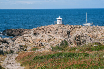 Fototapeta na wymiar White lighthouse on the top of Kullen peninsula, Kullaberg nature reserve, Skane, Sweden