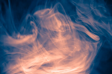 Clouds of colored flowing smoke on a dark background. Smoky extravaganza. Flying smoky vague fantasies.