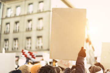 Crowd of people with placards and posters protest on the city street - Demonstrators on road for...