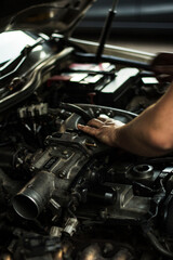 Fototapeta na wymiar Auto mechanic working on spare parts for a car