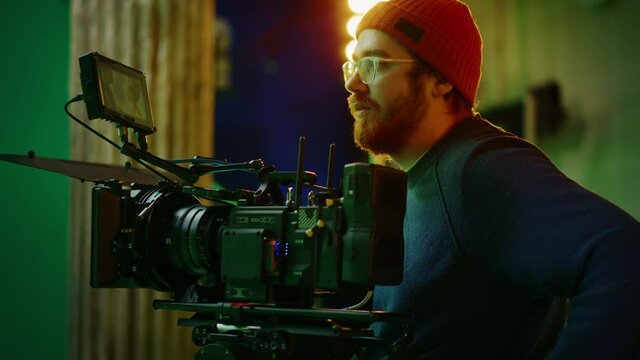 Portrait of Cameraman on Railway Trolley Shooting Green Screne Scene. Professional Crew on Big Budget Filmmaking. On Film Studio Set Shooting Historical Movie Green Screen Scene. Slow Motion Arc Shot