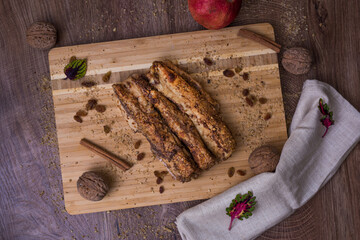 Traditional Walnut and Carob Crepes on a Wooden Cutting Board Decorated With Cinnamon, Raisins and Whole Walnuts