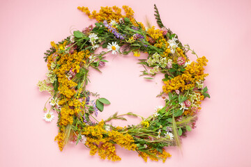 Beautiful wreath of wild flowers , typical Scandinavian midsummer decoration concept. Pink background. Top view © murziknata