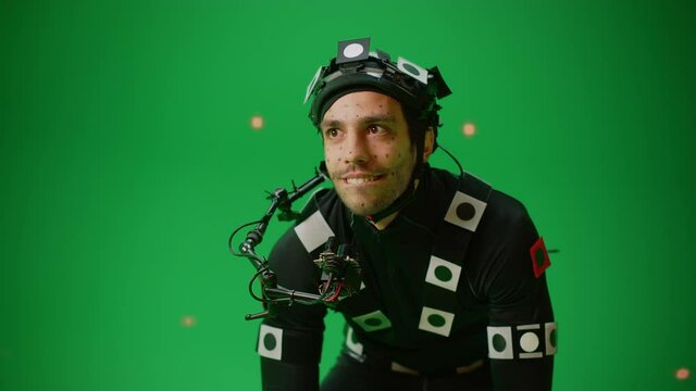 Actor Wearing Motion Caption Suit and Head Rig acts as an Animal or a Monster for CGI Green Screen Scene. Filmmaking On Film Studio Set Shooting Blockbuster Movie with Chroma Key. Closeup Medium Shot