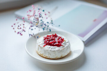 Camembert cheese baked with berry sauce on the background of the magazine