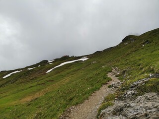 Hiking path between fiderepass hut and mindelheimer hut in the bavarian alps on a wet rainy spring day