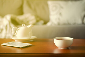 Cozy home interior with teapot, cup of tea and eBook
