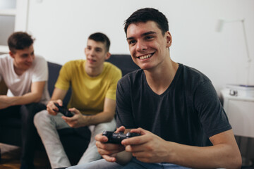 Fototapeta premium teenager boys having fun playing games on console at home