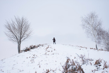 winter scene with a human up on hills in a frosty day 