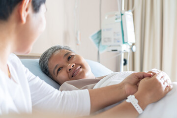 Obraz premium Love hope concept: Happy partner couple Visits lover holding hand for recovering that sick lying on bed in Hospital, Patient smiling with happy when get support from family,looking hopeful emotional