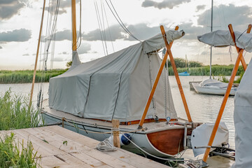  Traditional wooden boat moored up in covers on the River Thurne in the Norfolk Broads National...