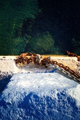 Rusty iron chain in harbor from above 
