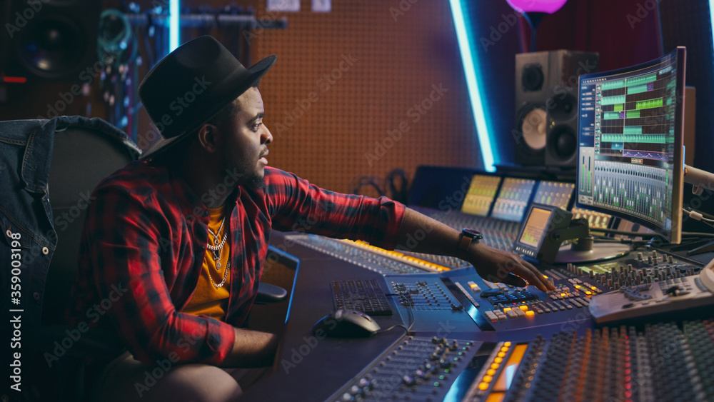 Leinwandbilder stylish audio engineer working in music recording studio, uses mixing board and software to create m