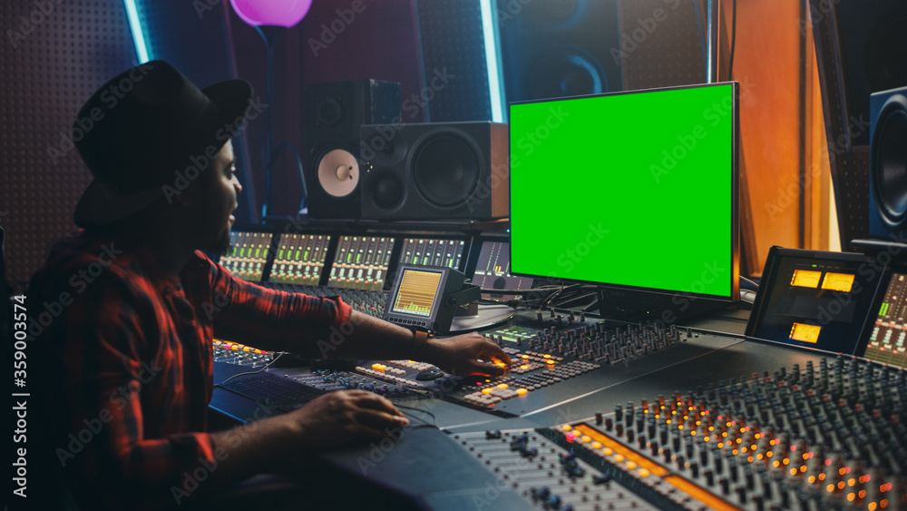 Aufkleber stylish audio engineer / producer working in music record studio, uses green screen computer, mixer 