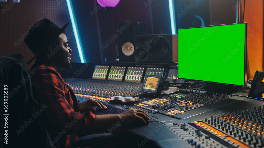 Poster stylish audio engineer / producer working in music record studio, uses green screen computer, mixer 