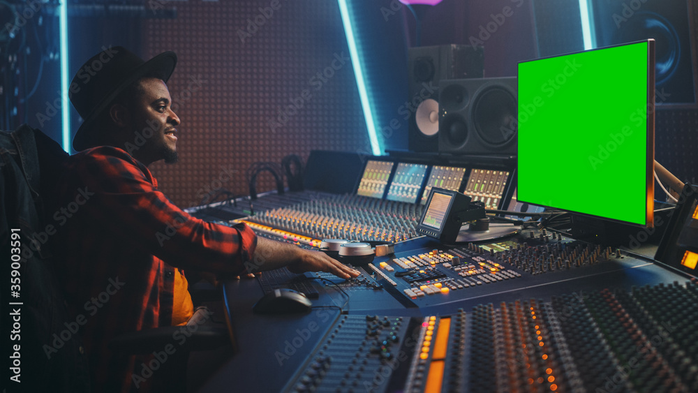 Aufkleber stylish audio engineer / producer working in music record studio, uses green screen chroma key compu
