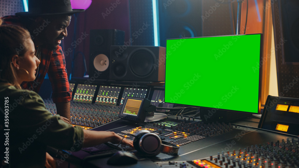 Poster Producer and Audio Engineer Working together in Music Record Studio on a New Album, Use Green Screen Computer, Control Desk for Mixing and Creating Hit Song. Artist and Musician Collaboration
