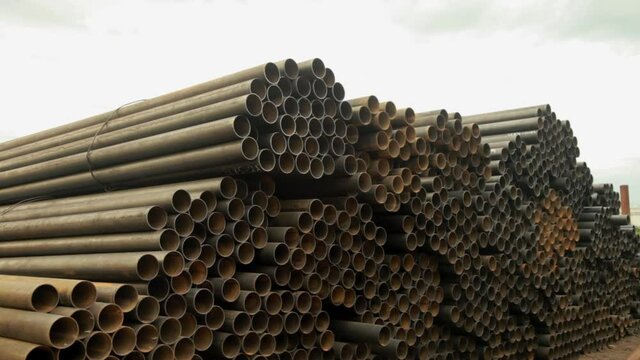 A large pile of steel pipes used for wells with water.Long shot.Frame shot from the slider.Water well drilling.