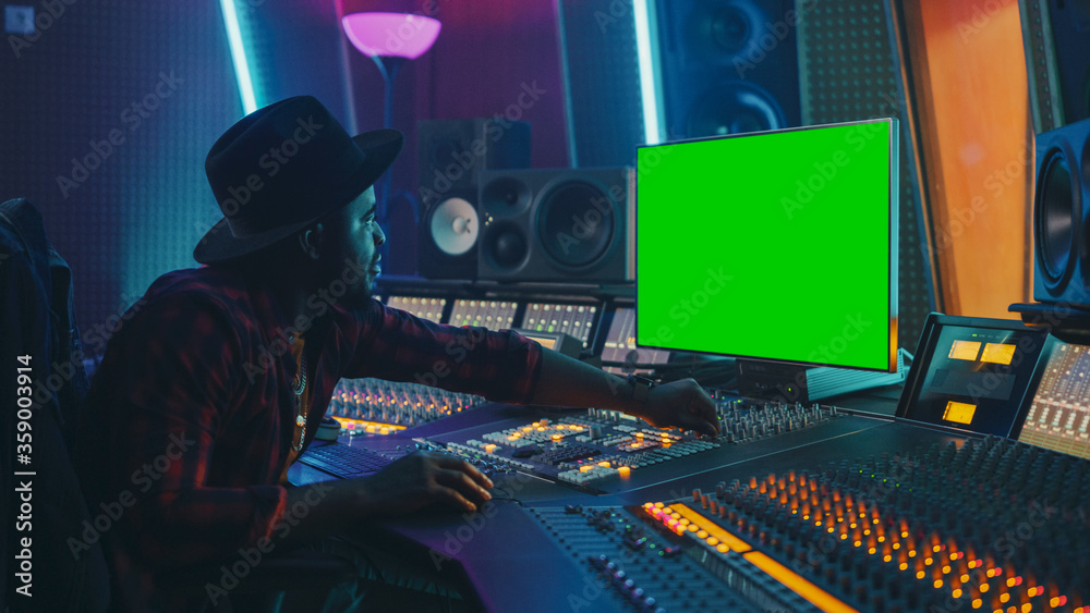 Poster stylish audio producer working in music record studio, uses green screen chroma key computer display