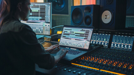 Modern Music Record Studio Control Desk with Laptop Screen Showing User Interface of Digital Audio...