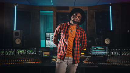 Portrait of Young Black Artist, Musician, Audio Engineer, Producer Wearing Stylish Hat and Standing...
