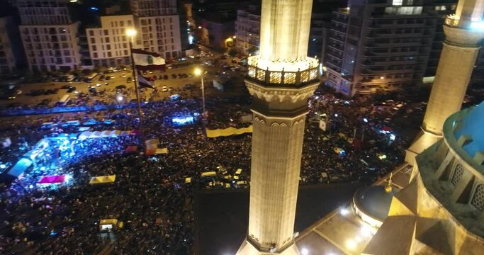 Beirut, Lebanon 2019 : night drone of Martyr square, with mosque minarets in foreground while thousands of protesters are revolting against government failure during the Lebanese revolution