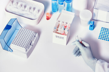 Fototapeta na wymiar Quick novel COVID-19 coronavirus test kit. 2019 nCoV pcr diagnostics kit. Hand in glove with the box. The kit detects covid19 virus in patients samples. Тesting system for real-time PCR amplification.