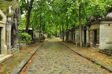 A stone-paved alley after the rain. The Pere Lachaise cemetery. Paris.