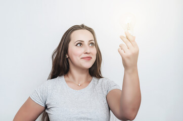 Girl holds a light bulb in hand. New idea, successful startup