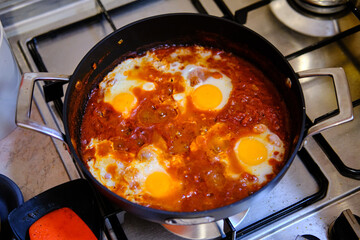 Shakshuka in a Frying Pan. Eggs Poached in Spicy Tomato Pepper Sauce.
