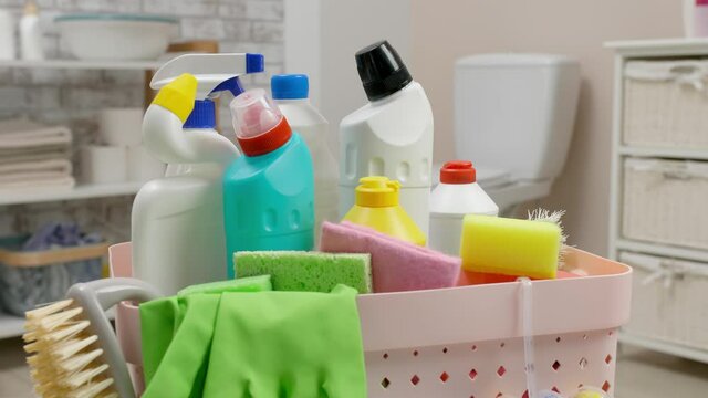 Basket with cleaning supplies in bathroom
