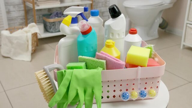 Basket with cleaning supplies in bathroom