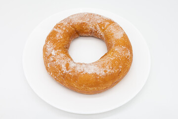 Large Sugared Greek Donut on a White Plate with a White Background