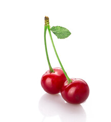 fresh cherry berries with a green leaf isolated on a white background