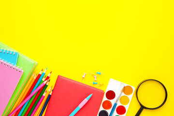 School supplies on yellow background with copy space. Back to school. Flat lay.