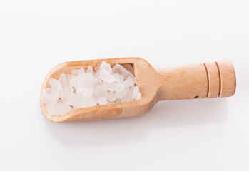 Fototapeta na wymiar large sea salt in a wooden spoon, isolated on a white background