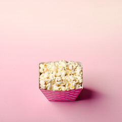 Paper box with popcorn on pink background
