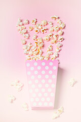 Paper box with popcorn on pink background