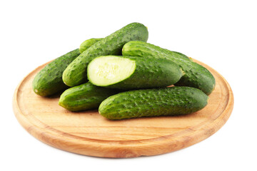 Fresh cucumbers on a wooden cutting board isolated on white background