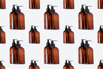 pattern of brown hand soap bottles on a light background in hard light