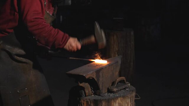 Herrero dando martillazos en su forja. 