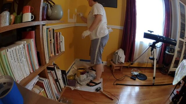 time lapse woman painting patch on the wall in house living room