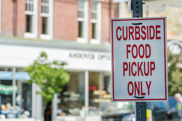 Close-up of sign outside of restaurant stating "Curbside Food Pickup Only" during phased reopening of businesses during the Covid-19 pandemic.