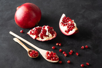 Composition with ripe pomegranates on black background. Space for text