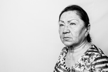 Fototapeta premium Portrait of elderly senior woman, back and white photo. Thinking about passed years. Loneliness, solitude. Black and white photo.