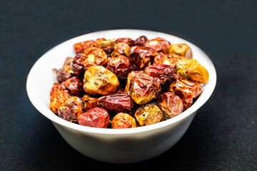 a bunch of round red chillies in a white bowl